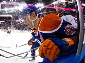 The Edmonton Oilers' Ryan Nugent-Hopkins (93) battles the New Jersey Devils' Lee Stempniak (20) and Adam Larsson (5) during first period NHL action at Rexall Place, in Edmonton, Alta. on Friday Nov. 20, 2015. David Bloom/Postmedia Network