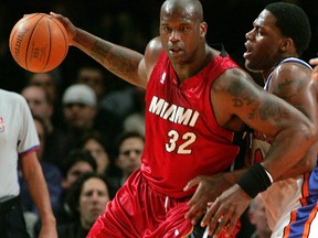 Miami Heat centre Shaquille O’Neal (left) drives into New York Knicks centre Eddy Curry in the first quarter of their NBA game in New York’s Madison Square Garden March 19, 2006. (Postmedia Network wire photo)