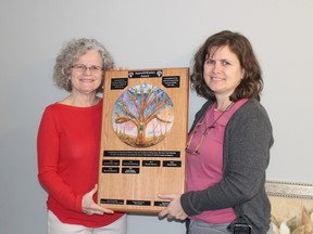 Phyl McCrum and Sue Barg, both members of the International Women's Day committee in Oxford, show off the AppreSHEation Award plaque. The award is presented to a woman or group of women making life better for other ladies in Oxford County. (MEGAN STACEY/Sentinel-Review)