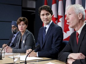 Prime Minister Justin Trudeau (2nd R) listens to Foreign Minister Stephane Dion (R) speak during a news conference in Ottawa, Canada, February 8, 2016. Also pictured are Defence Minister Harjit Sajjan (L) and International Development Minister Marie-Claude Bibeau. REUTERS/Chris Wattie