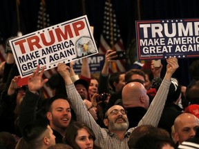 Supporters celebrate as they hold placards at Republican U.S. presidential candidate Donald Trump's 2016 New Hampshire  primary election night rally in New Hampshire. (REUTERS)