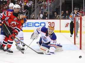 Oilers goalie Cam Talbot stops Devils forward Joseph Blandisi during the second period of Tuesday's game in Newark, N.J. (USA TODAY SPORTS)