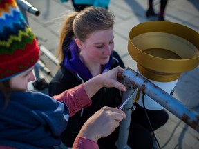 Shayna Harris and Amanda Scoula fix a rain gauge to the roof of the Tory Building on the University of Alberta Campus on February 9, 2016. A group of University of Alberta undergraduate students took to the roof of the Tory Building to setup research-grade weather stations to monitor a range of standard meteorological parameters, all part of their environmental instrumentation class, a core course for the environmental earth sciences degree.