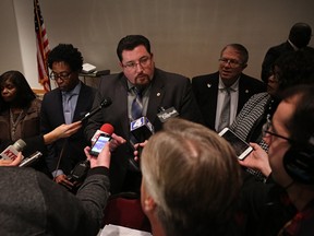 Ferguson mayor Mayor James Knowles III, centre, talks to the media after the Ferguson, Mo., city council meeting in Ferguson on Tuesday, Feb. 9, 2016, where the council voted to approve a modified consent decree with the United States Department of Justice. It is unclear if the Department of Justice will agree to the modifications the city made to the agreement. (David Carson/St. Louis Post-Dispatch via AP)