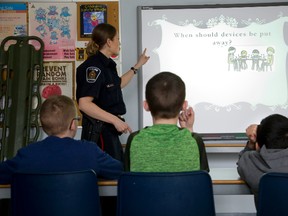 Const. Shayna Boland teaches Internet safety Tuesday to Sherwood Fox elementary school students Jamie Keith-Topping, left, Jeffrey McKay and Abdul Abdulrahman at the Safety Village in London. Police school safety officers have noticed pupils just out of primary grades have multiple social media accounts. (DEREK RUTTAN, The London Free Press)