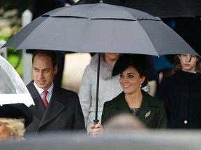 Britain's Prince William and his wife Kate the Duchess of Cambridge shelter from the rain as they leave after attending the traditional Christmas Day church service at St. Mary Magdalene Church in Sandringham, England, Friday, Dec. 25, 2015.  (AP Photo/Matt Dunham)