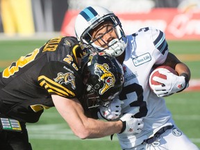 Toronto Argonauts running back Brandon Whitaker (3) gets tackled by Hamilton Tiger-Cats defensive back Craig Butler (28) during the CFL Eastern Division semifinal in Hamilton Sunday, Nov. 15, 2014. (THE CANADIAN PRESS/Nathan Denette)