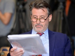 IAAF President Sebastian Coe takes a look at a paper during a press conference about WADA's Independent Commission Report in Munich, Germany, on Thursday, Jan. 14, 2016. (Kerstin Joensson/AP Photo)