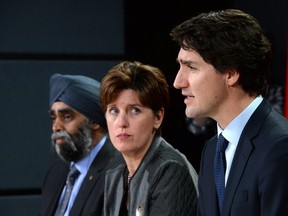 Prime Minister Justin Trudeau answers a question as he is joined by Minister of National Defence Harjit Sajjan, left, and Minister of International Development and La Francophonie Marie-Claude Bibeau during a press conference at the National Press Theatre in Ottawa on Monday, Feb. 8, 2016. THE CANADIAN PRESS/Sean Kilpatrick