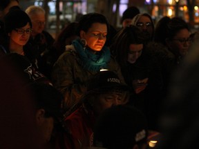 Robin Eaglewhistleblower holds a candle surrounded by supporters at a vigil for missing and murdered indigenous women at Churchill Square in Edmonton on Wednesday, Feb. 10, 2016. This vigil was held in advance of a pre-inquiry hosted by the Assembly of First Nations, where input from families and delegates will shape the National Inquiry for Missing and Murdered Indigenous Women and Girls.