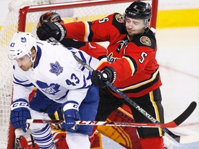 Maple Leafs forward Nazem Kadri is shoved from behind by Flames defenceman Mark Giordano on Tuesday night in Calgary. At another point in the game, Giordano caught Kadri with his head down, a hit that had the centre chasing the blueliner for much of the evening. (The Canadian Press)