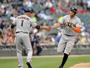 Third base coach Tim Flannery #1 of the San Francisco Giants congratulates Hunter Pence #8 of the San Francisco Giants as he rounds the bases after hitting a solo home run during the first inning against the Chicago White Sox at U.S. Cellular Field on June 17, 2014 in Chicago, Illinois.   Brian Kersey/Getty Images/AFP