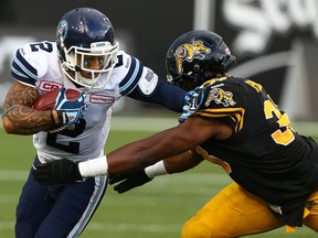 Chad Owens of the Toronto Argos gets around Frederic Plesius of the Hamilton Tiger-Cats during CFL action at Tim Hortons Field in Hamilton Monday August 3, 2015. (Dave Abel/Toronto Sun/Postmedia Network)