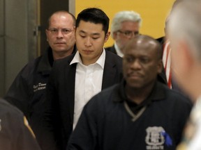 New York City Police officer (NYPD) Peter Liang is led from the court room at the Brooklyn Supreme court in the Brooklyn borough of New York February 11, 2016. Liang was convicted of manslaughter and official misconduct on Thursday for fatally shooting an unarmed black man in a darkened public housing stairwell in 2014. REUTERS/Brendan McDermid