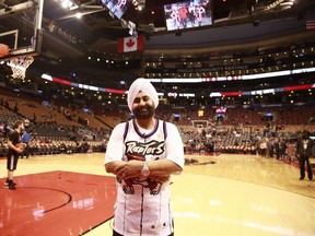 Nav Bhatia, posing on the ACC floor before a Raptors game, uses his 10 season tickets to allow thousands of underprivileged youngsters to see an NBA game every year.