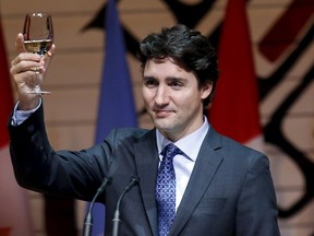 Prime Minister Justin Trudeau raises his glass for a toast during a dinner at the Canadian Museum of History in Gatineau, Que., on Feb. 11, 2016. Trudeau will mark his 100th day as prime minister today with a "massive" boost to a program that helps students get summer jobs. (REUTERS/Chris Wattie)
