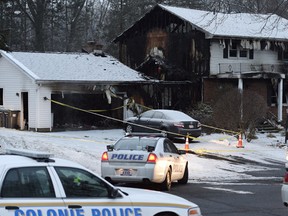 Law enforcement officials investigate a fatal fire, Wednesday, Feb. 10, 2016, in Colonie, N.Y. It's believed a local police officer killed his wife, son and himself inside as the fire started. (Skip Dickstein/The Albany Times Union via AP)