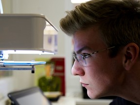 Tim Miller/The Intelligencer
Colm O’Sullivan of Prince Edward County keeps close watch as an object is created on a 3D printer in the learning commons at Nicholson Catholic College on Thursday in Belleville. The learning commons is part of a nationwide trend to reinvent the school library.