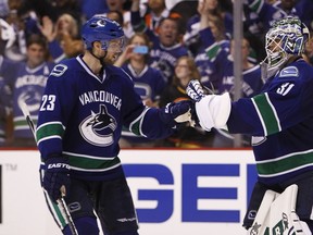Goaltender Eddie Lack of the Vancouver Canucks celebrates with teammate Alex Edler (left) during Game Two of the Western Conference quarterfinals at Rogers Arena on April 17, 2015 in Vancouver. (Ben Nelms/Getty Images/AFP)