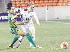 Canada?s Jesse Fleming is held up by Guyana?s Calaigh Copland during the second half of a CONCACAF Olympic qualifying tournament soccer game Thursday in Houston. Canada won 5-0. (The Associated Press)