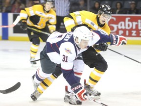 Kingston Frontenacs' Warren Foegele ties up Windsor Spitfires' Mikhail Sergachev during the first period of Ontario Hockey League action on Friday at the Rogers K-Rock Centre on Friday night. (Elliot Ferguson/The Whig-Standard)