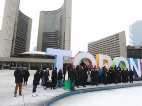 CUPE (Canadian Union of Public Employees) members pose for a solidarity photo in front of the Toronto sign on Friday, February 12, 2016. Jack Boland/Toronto Sun/Postmedia Network