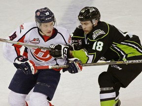 Lethbridge Hurricanes winger Brayden Burke, left, is checked by Edmonton Oil Kings Kobe Mohr on Saturday at Rexall Place.