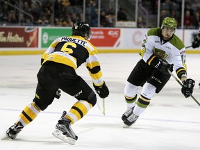 North Bay Battalion centreman Brett McKenzie attempts to make his way through Kingston Frontenac defenceman Jacob Paquette during the first period of Ontario Hockey League action at the Rogers KRock Centre in Kingston, Ont. on Saturday February 13, 2016. Steph Crosier/Kingston Whig-Standard/Postmedia Network