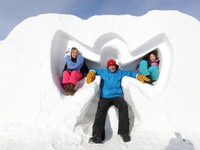 Graham Kaluzny and nieces May (left), 6, and Katya Spewak, 9, inhabit a snow angel during Festival du Voyageur in St. Boniface on Saturday. (KEVIN KING/Winnipeg Sun)