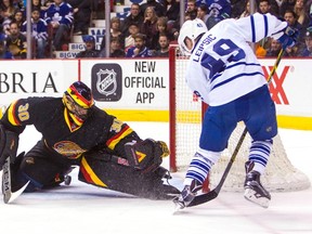 Canucks goaltender Ryan Miller makes a save against Maple Leafs' Brendan Leipsic during the first period on Saturday in Vancouver. Leipsic did score later, notching a goal in his NHL debut. (THE CANADIAN PRESS/PHOTO)