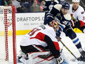 Ottawa Senators' Craig Anderson, left, makes a save against Columbus Blue Jackets' Boone Jenner during the second period of an NHL hockey game Saturday, Feb. 13, 2016. (AP Photo/Jay LaPrete)