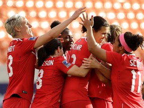 Canada's Christine Sinclair, center, is congratulated after scoring a goal against Trinidad & Tobago during the second half of a CONCACAF Olympic qualifying tournament soccer match Sunday, Feb. 14, 2016, in Houston. Canada won 6-0. (AP Photo/David J. Phillip)