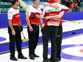 Skip Kevin Koe and third Marc Kennedy hug as teammates Brent Laing, left, and Ben Hebert look on Sunday after the team's win over Charley Thomas at the Boston Pizza Cup in Camrose. (Amielle Christopherson)