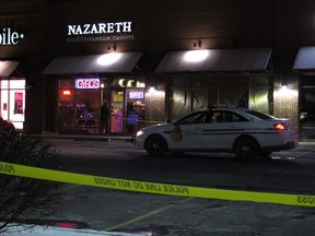 Police talk inside the Columbus, Ohio, restaurant where they say a man attacked several people with a machete on Thursday, Feb. 11, 2016. They say the man fled the scene and was later fatally shot by police. (AP Photo/Kantele Franko)