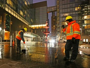 Workers clean up glass that fell from a window of the The Four Seasons Hotel on Yorkville Ave. (DAVE ABEL, Toronto Sun)