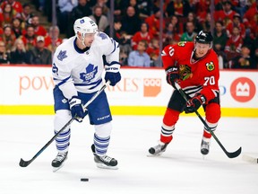 Maple Leafs’ Brad Boyes (left) looks to shoot the puck as Blackhawks’ Dennis Rasmussen gives chase during the first period on Monday night at the United Center in Chicago.  The Hawks entered the night on an uncharacteristic three-game losing streak. (AP/PHOTO)