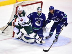 Wild forward Jason Zucker (16) rushes the puck against Canucks defenceman Christopher Tanev (8) as goaltender Jacob Markstrom (25) watches the play during second period NHL action in Vancouver on Monday, Feb. 15, 2016. (Anne-Marie Sorvin/USA TODAY Sports)