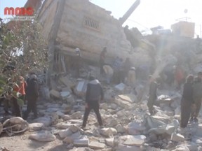 People gather near a destroyed building said to be a Medecins Sans Frontieres (MSF) supported hospital in Marat al Numan, Idlib, Syria, February 15, 2016 in this still image taken from a video on a social media website. French charity Doctors Without Borders/Medecins Sans Frontieres (MSF) said in a statement that at least eight staff were missing after four rockets hit a hospital that it supported in the province of Idlib in north western Syria. (REUTERS/Social Media Website via Reuters TV)