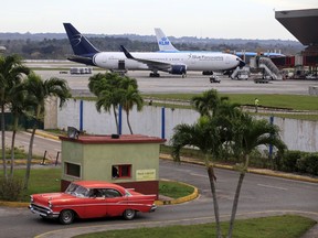 Blue Panorama and KLM aircrafts are seen as a taxi drives out of a parking lot at Havana's Jose Marti International Airport February 15, 2016. Top U.S. officials will travel to Havana on Tuesday (February 16) to sign an aviation pact that restores scheduled airline service between the United States and Cuba for the first time in more than 50 years. REUTERS/Enrique de la Osa