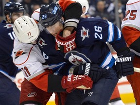 Carolina Hurricanes' Jordan Staal (left) grabs Winnipeg Jets' Blake Wheeler after a whistle during the second period of their NHL hockey game in Winnipeg March 30, 2013.