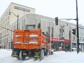 A City of Kingston plow turns onto Princess Street in the city's downtown core on Tuesday Feb. 16, 2016. (Elliot Ferguson/The Whig-Standard)