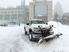 A city truck plows snow in front of Ottawa City Hall during a major snowfall on Thursday January 21, 2016. Errol McGihon