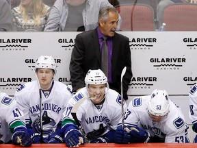 Canucks head coach Willie Desjardins shouts instructions to his players as he stands behind Jared McCann (91), Radim Vrbata (17), and Bo Horvat (53) during NHL action against the Coyotes in Glendale, Ariz., on Feb. 10, 2016. (Ross D. Franklin/AP Photo)