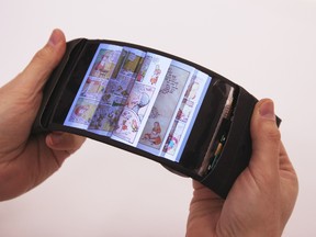 User navigating pages by bending the smartphone; feels pages flip through fingers. Handout photo.