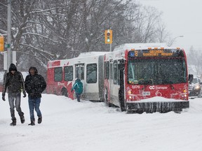 An bus blocks afternoon commuters on Alta Vista Drive after it got stuck in the snow as the region deals with a major snow storm on Feb. 16. (Wayne Cuddington, Postmedia Network)
