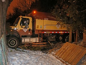 A garbage truck is seen at the back of a house after crashing through yards in Thornhill Tuesday, February 16, 2016. (Michael Peake/Toronto Sun)