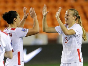 Canada's Rebecca Quinn (right) celebrates with Melissa Tancredi after scoring a goal against Guatemala during the second half of a CONCACAF Olympic qualifying tournament match in Houston on Tuesday, Feb. 16, 2016. (David J. Phillip/AP Photo)