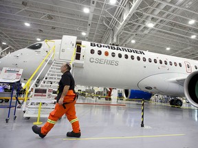 A Bombardier worker walks past the CS300 Aircraft in the hangar prior to a test flight in Mirabel, Quebec, in this Feb. 27, 2015 file photo.   REUTERS/Christinne Muschi/Files
