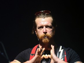 Jesse Hughes frontman of California, USA, rock band Eagles of Death Metal makes a heart sign as the rock band performs Tuesday Feb. 16, 2016, at the Olympia concert hall in Paris, France.  (Jean-Nicolas Guillo/Le Parisien via AP)