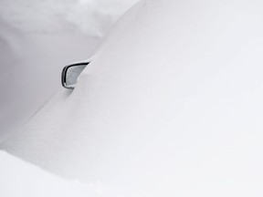A side mirror of a car sticks out from underneath a blanket of snow. THE CANADIAN PRESS/Adrian Wyld